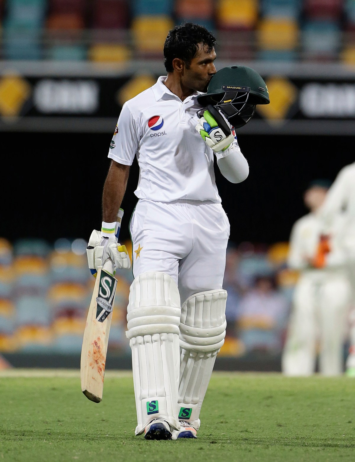 Pakistan's Asad Shafiq reaches 100 runs during play on day four of the first cricket test between Australia and Pakistan in Brisbane, Australia, Sunday, Dec. 18, 2016. (AP Photo/Tertius Pickard)