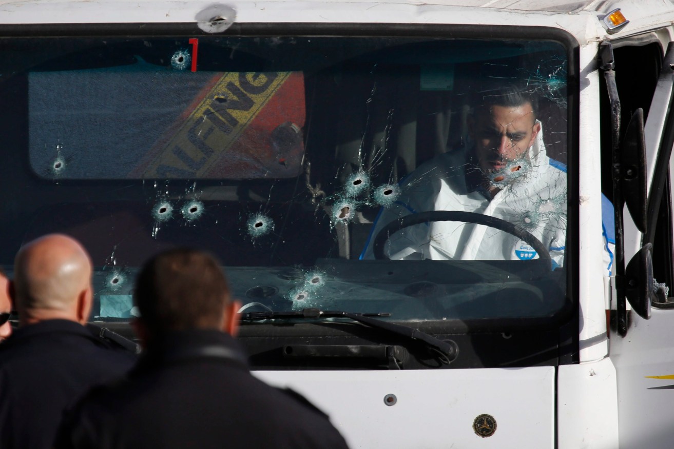An Israeli police forensic investigator examines the cabin of the bullet-hold riddled truck. Photo: EPA/Abir Sultan