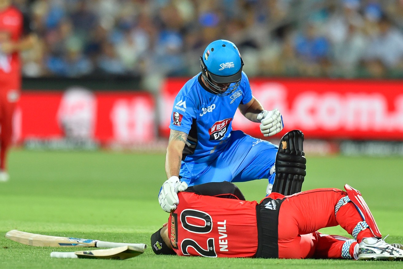 Jono Dean of the Strikers checks on the Renegades' Peter Nevill after he was hit in the head by a wayward bat last night. Photo: David Mariuz / AAP