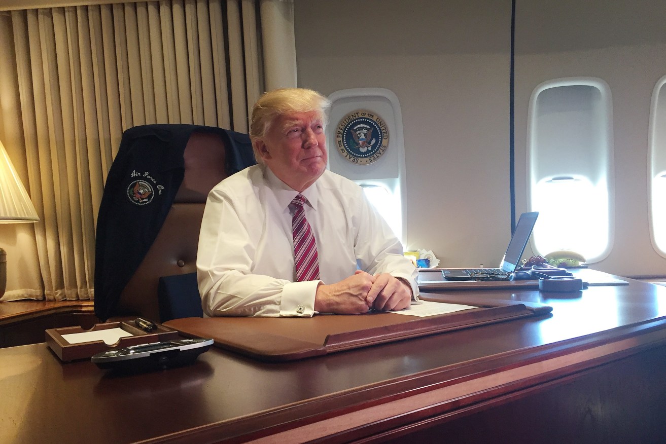 President Trump sits at his desk aboard Air Force One. Photo: EPA/David Nakamura