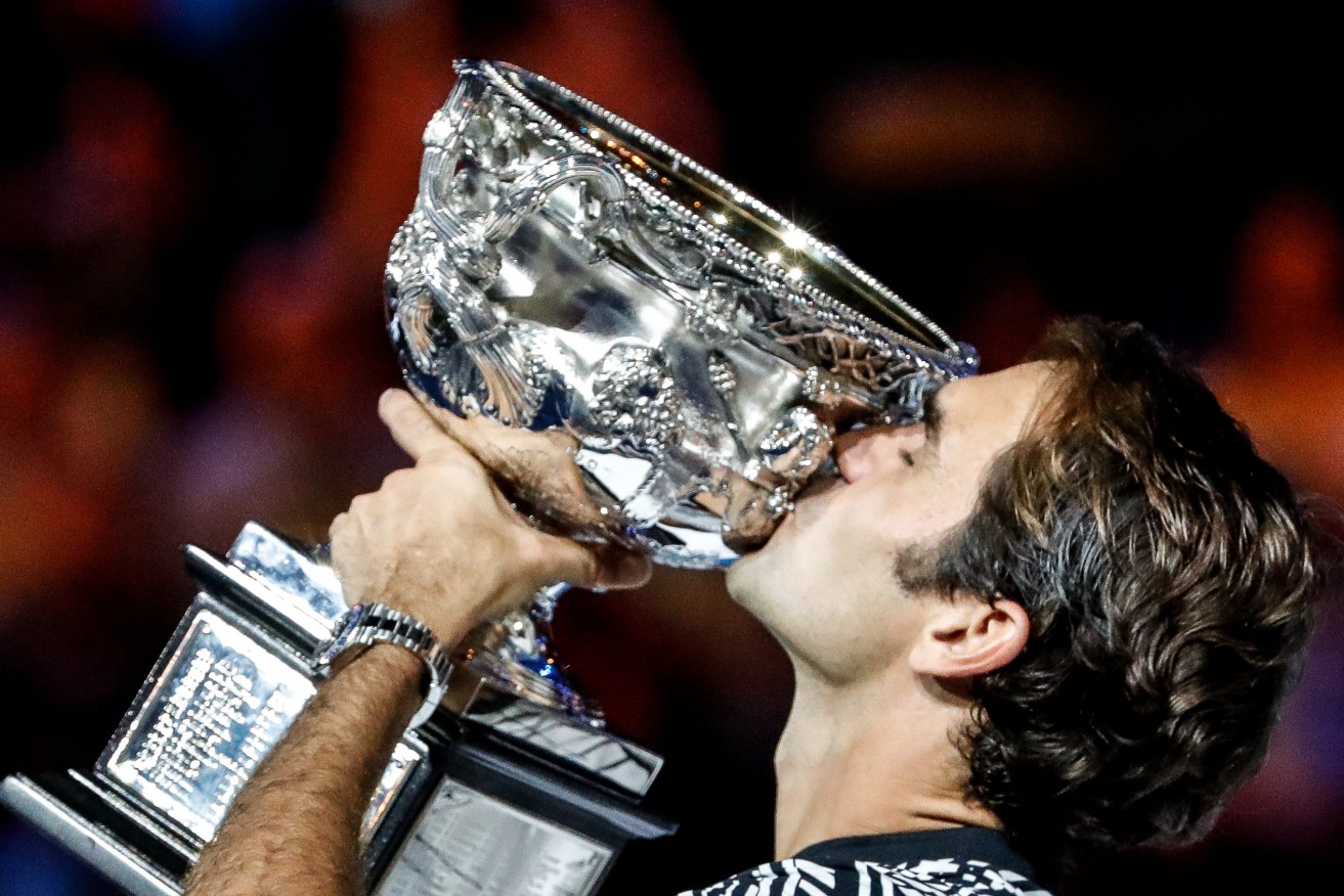 Roger Federer kisses the trophy after winning the Australian Open Men's Singles final against Rafael Nadal. Photo: Made Nagi / AAP
