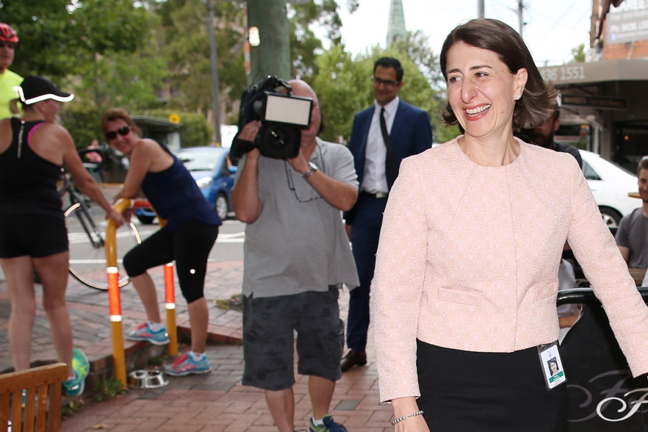 NSW Treasurer Gladys Berejiklian walks past locals near her electorate office in Naremburn, Sydney. She says she will stand for the role of 45th premier of NSW. Image: AAP