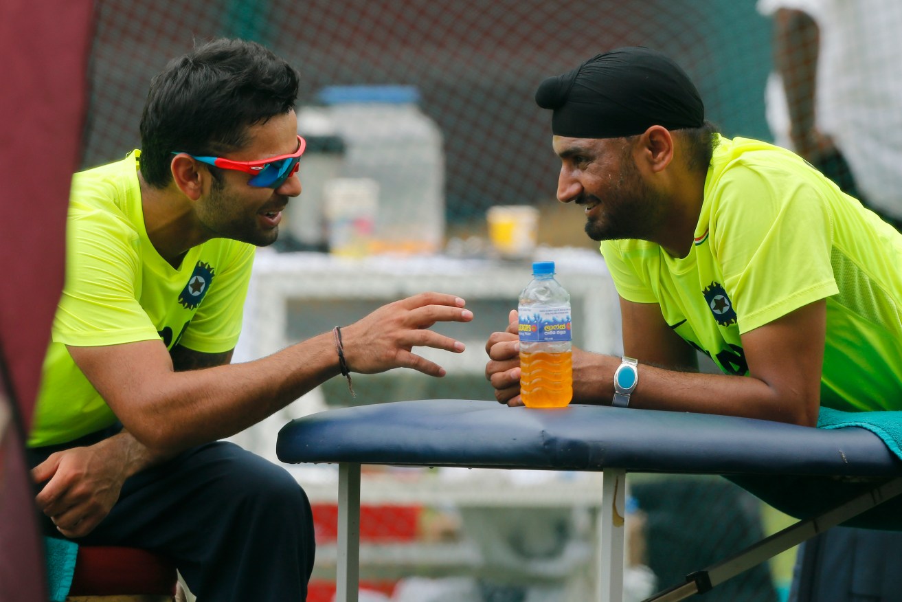 Virat Kohli sharing a light moment with then-teammate Harbhajan Singh in 2012. Photo: Eranga Jayawardena / AP