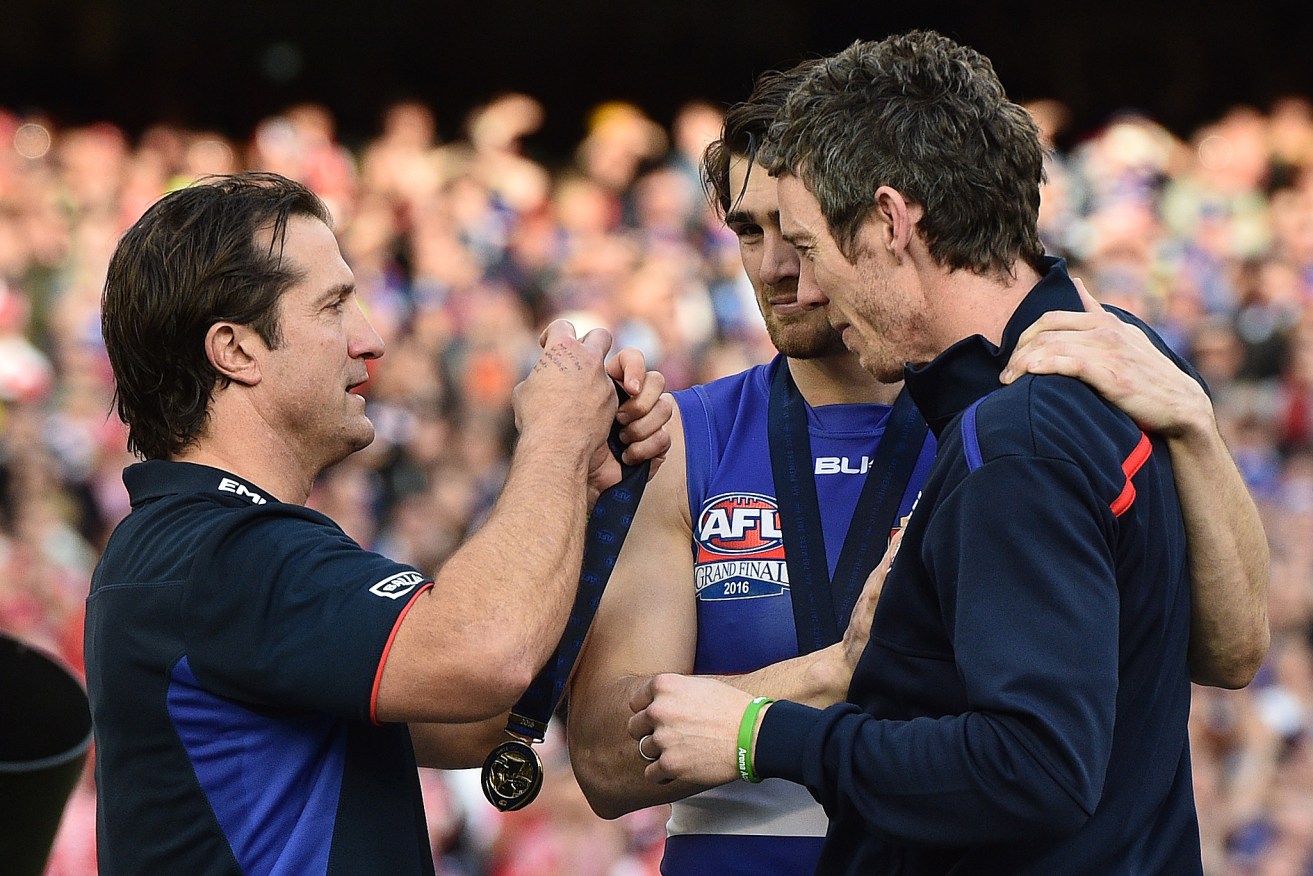 Bob Murphy, flanked by stand-in skipper Easton Wood, was famously handed Bulldogs coach Luke Beveridge's premiership medal on Grand Final day. Photo: Julian Smith / AAP