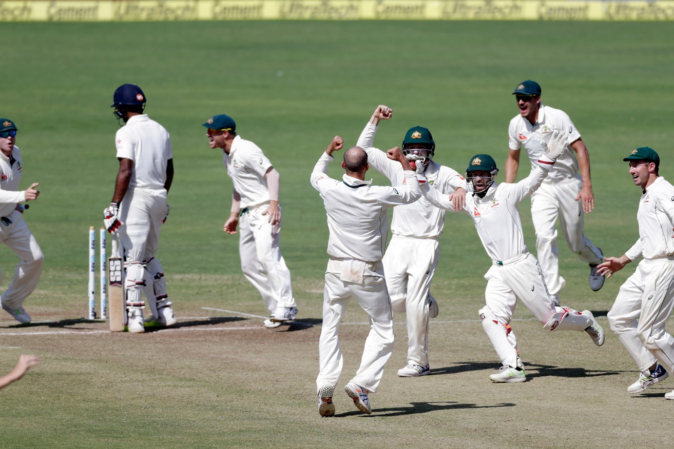 The Australian team, with captain Steve Smith left, celebrate the final Indian wicket in Pune. Photo: Rajanish Kakade / AP