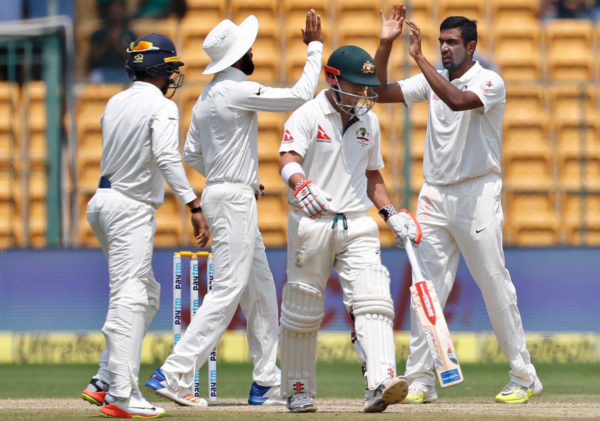 India's Ravichandran Ashwin, right, celebrates with teammates the dismissal of Australia's David Warner, second right, during the fourth day of their second test cricket match in Bangalore, India, Tuesday, March 7, 2017. (AP Photo/Aijaz Rahi)