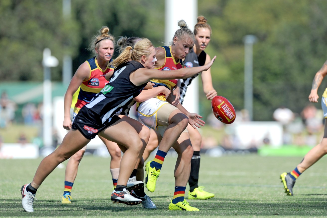 Erin Phillips gets a kick away under pressure during yesterday's come-from-behind win over Collingwood. Photo: Joe Castro / AAP