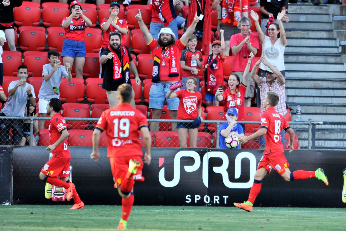 Adelaide players celebrate the late penalty that put them in front. Photo: David Mariuz / AAP