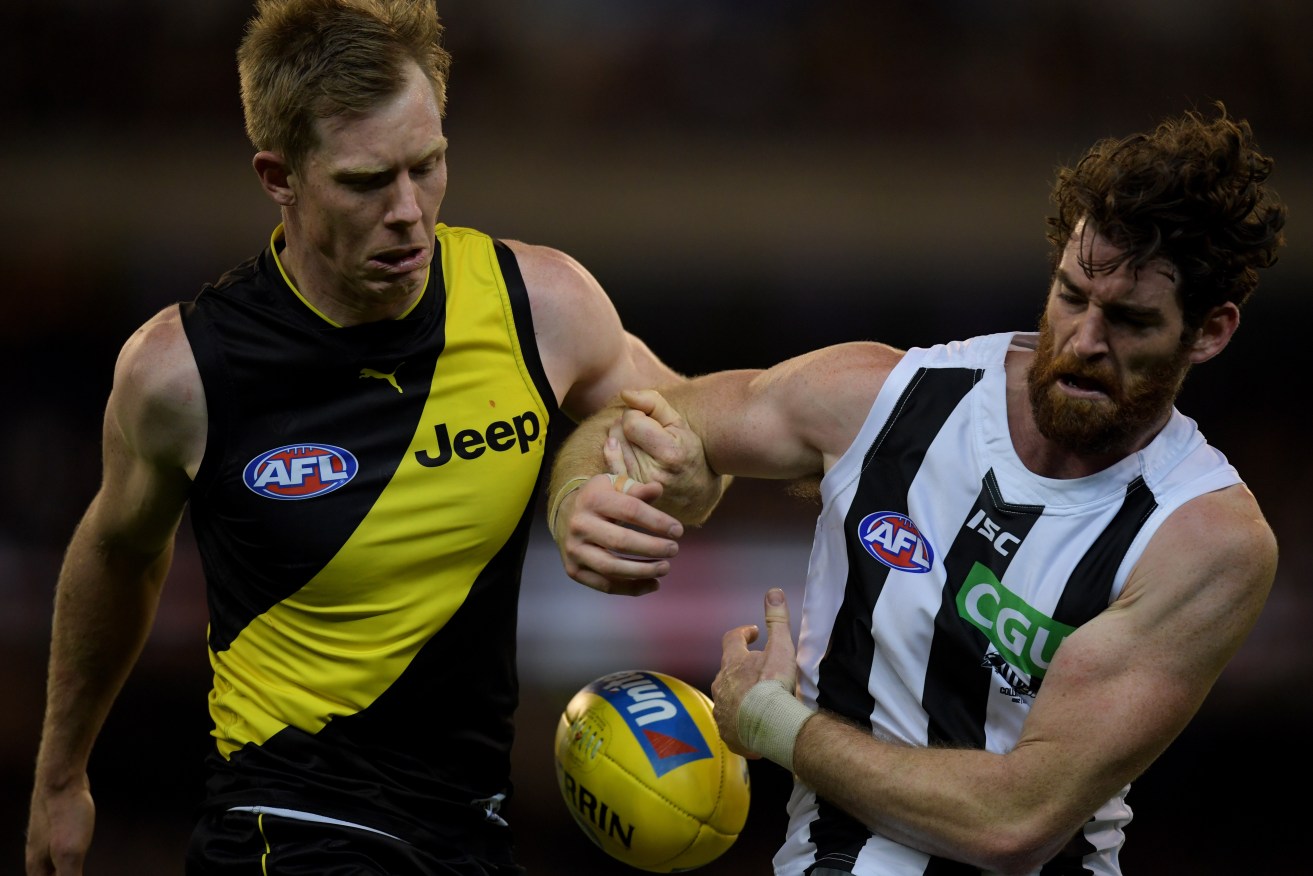 Jack Riewoldt of the Tigers tackles Collingwood's Tyson Goldsack. Photo: Tracey Nearmy / AAP