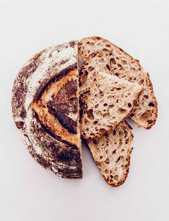 A cut loaf from "Sourdough" by Casper Andre Lugg and Martin Ivar Hveem Fjeld published by Hardie Grant Books. Photographer: Simen Grytøyr