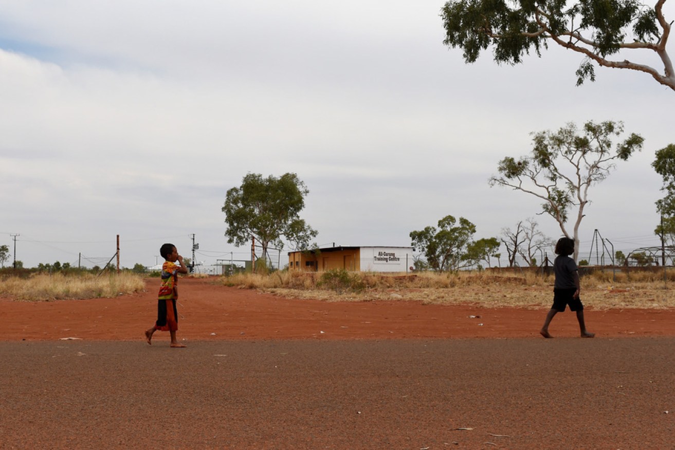 Children walk along a road in the Aboriginal community of Ali Curung, 400 km north of Alice Springs. AAP Image/Dan Peled