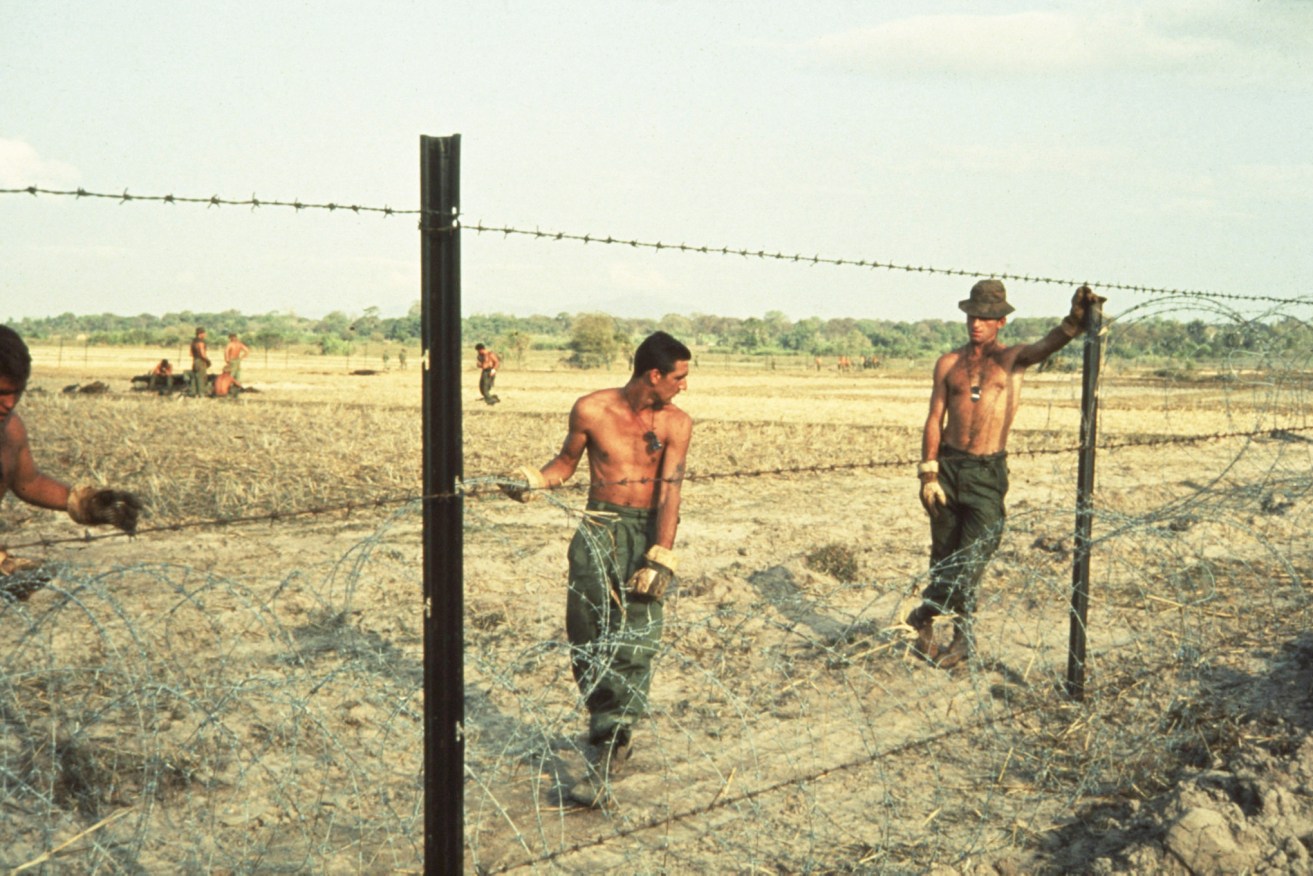 Lingering effects: Australians soldiers fence off a minefield in the Phuoc Tuy province during the Vietnam War in 1966. Photo: AAP/Australian War Memorial