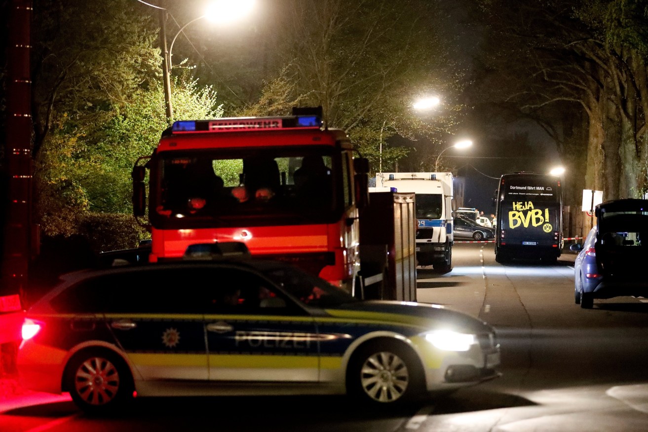 Borussia Dortmund's team bus is seen on a street after it was hit by three explosions. Photo: Friedemann Vogel / EPA