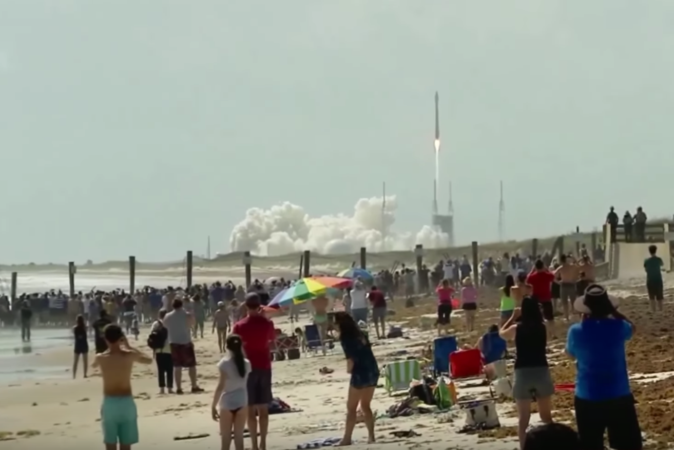 Onlookers watch the launch of the Atlas V rocket at Cape Canaveral overnight. Photo: YouTube/NASA