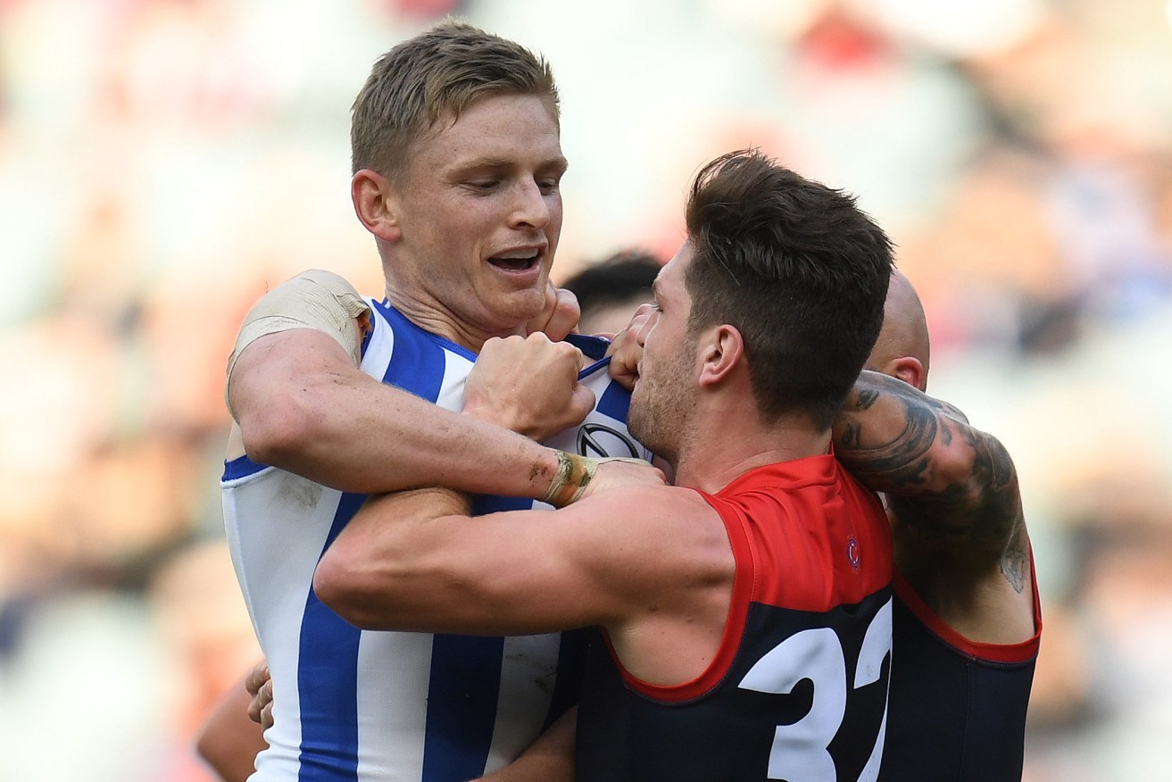 Tomas Bugg of the Demons gets hold of North Melbourne's Jack Ziebell during Sunday's spiteful encounter. Photo: Julian Smith / AAP