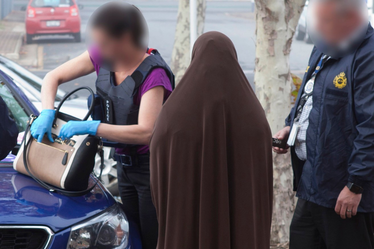 An image of the woman with Australian Federal Police officers, released by the AFP.