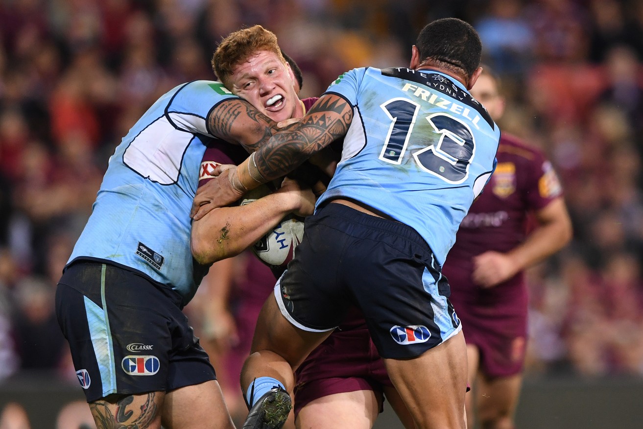 Dylan Napa is wrapped up in last night's Origin I. Photo: Dave Hunt / AAP