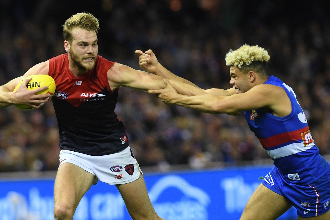 Jack Watts takes on Jason Johannisen as the Demons account for the reigning premiers. Watts was earlier involved in some social media banter at the Bulldog's expense. Photo: Julian Smith / AAP
