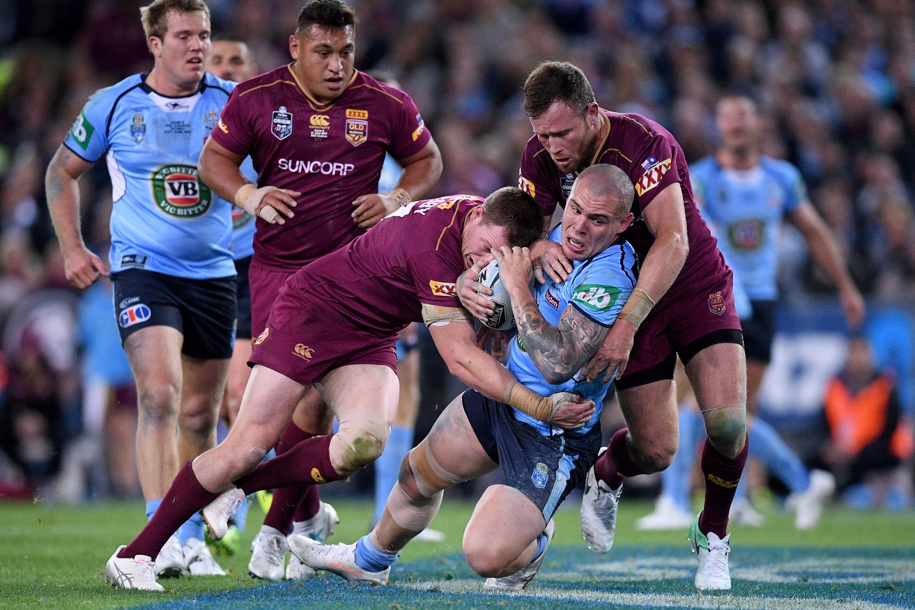 Maroons Tim Glasby, left, and Gavin Cooper tackle David Klemmer during last night's Origin win at Sydney's ANZ Stadium. Photo: Dan Himbrechts / AAP