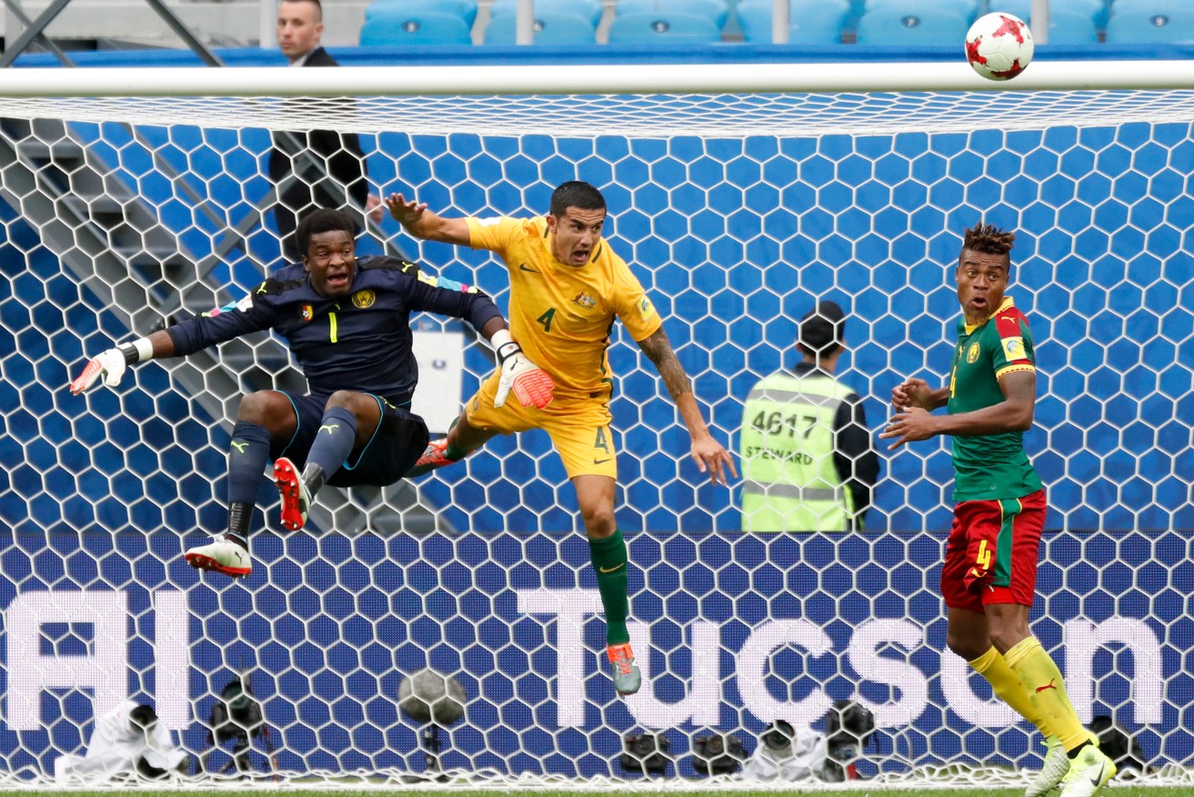 Cameroon goalkeeper Fabrice Ondoa, Australia's Tim Cahill and Cameroon's Adolphe Teikeu contest the ball. Photo: Pavel Golovkin / AP