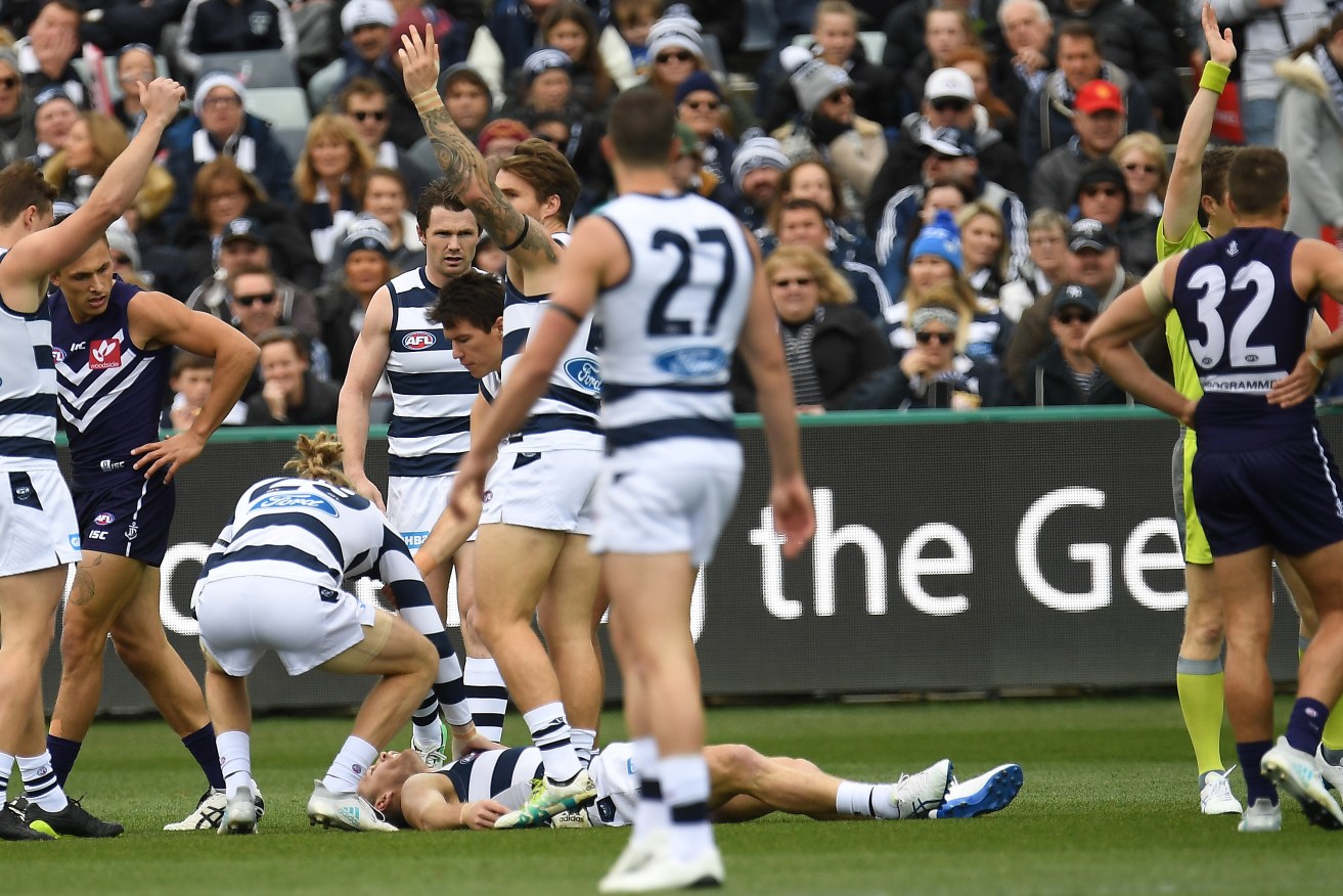 Joel Selwood lies on the ground after being knocked unconscious early in yesterday's game. Photo: Julian Smith / AAP