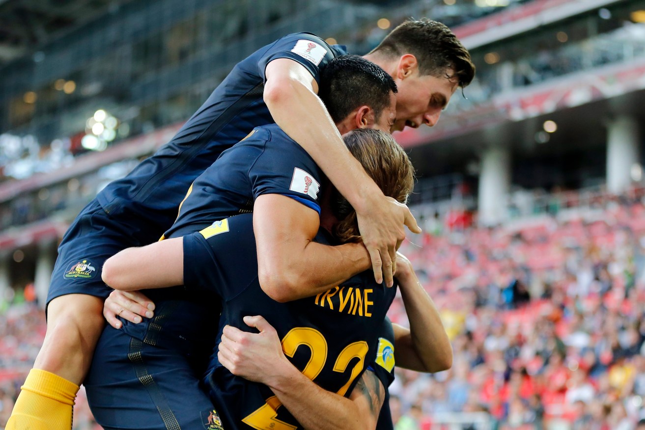 Australian players celebrate as the Socceroos go a goal up against Chile. Photo: YURI KOCHETKOV / EPA