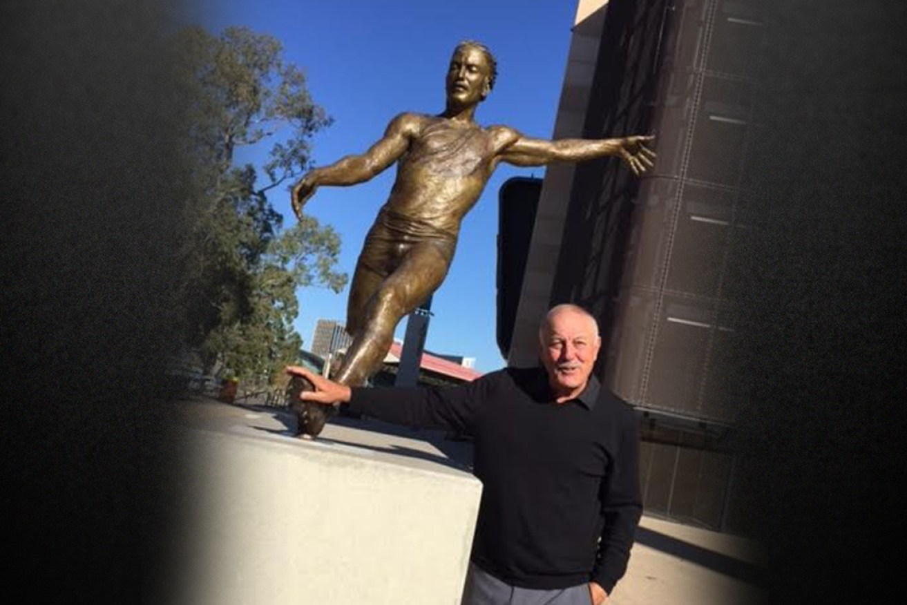 AFL Legend Malcolm Blight poses with his statue today. Photo: Steve Larkin / AAP