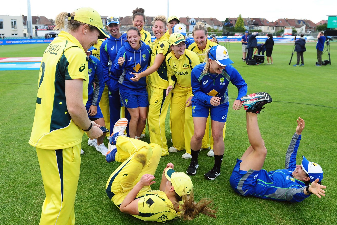 ALL SMILES: Ellyse Perry pushes Nicole Bolton out of shot as Alex Blackwell attempts to take a team photo after Australia's win over India. Photo: International Cricket Council via AAP