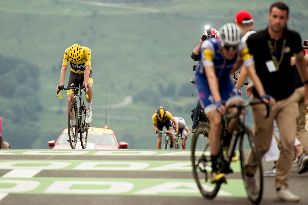 Chris Froome loses his lead overall as he crosses the finish line, with Dan Martin in the foreground at the summit of the Peyragudes. Photo via AAP