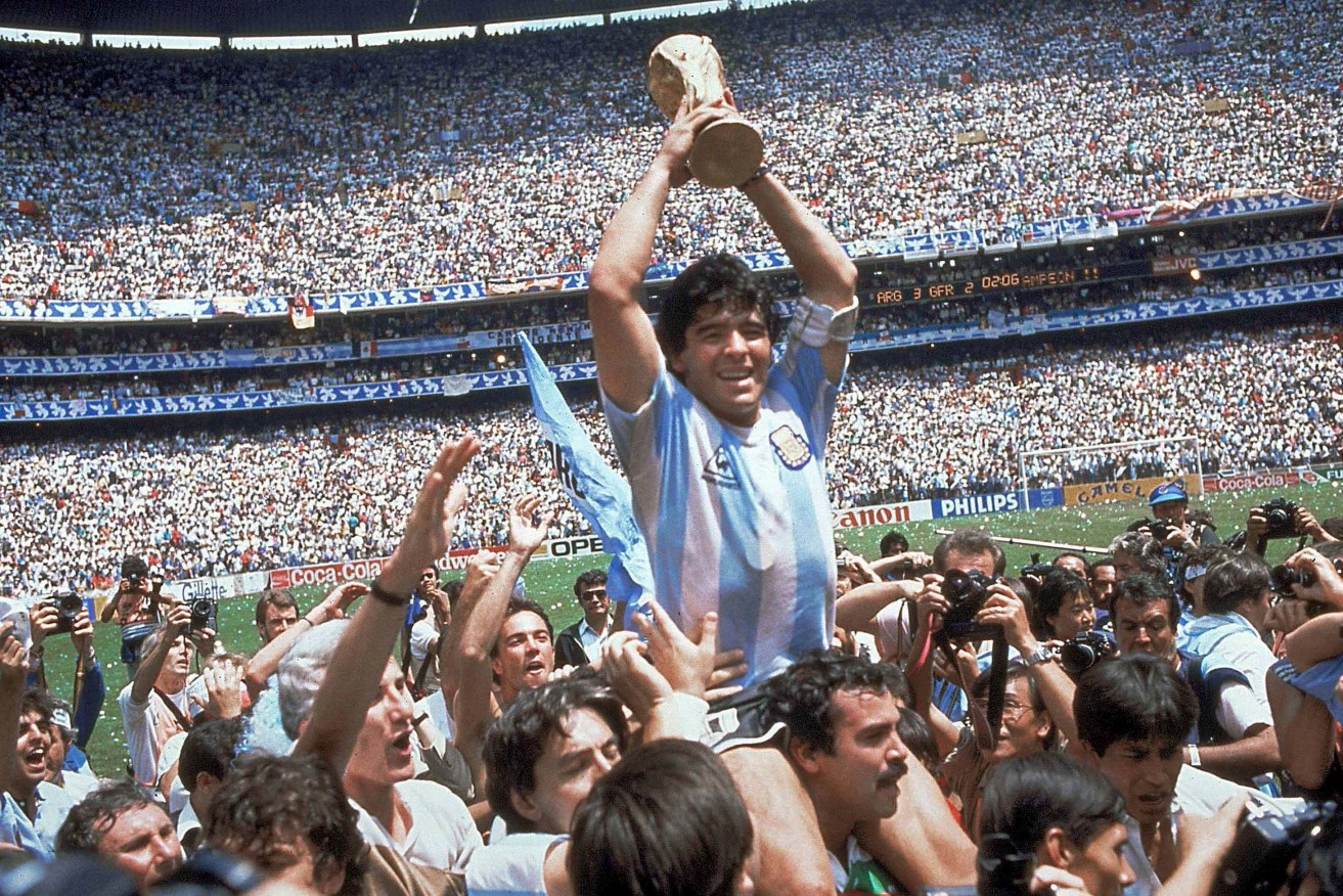 Diego Maradona holds up the Jules Rimet trophy after Argentina defeated West Germany 3-2 in the 1986 World Cup final -
 but it was his goal in the 51st minute of the quarter final against England that has endured in public memory. Photo: Carlo Fumagalli / AP
