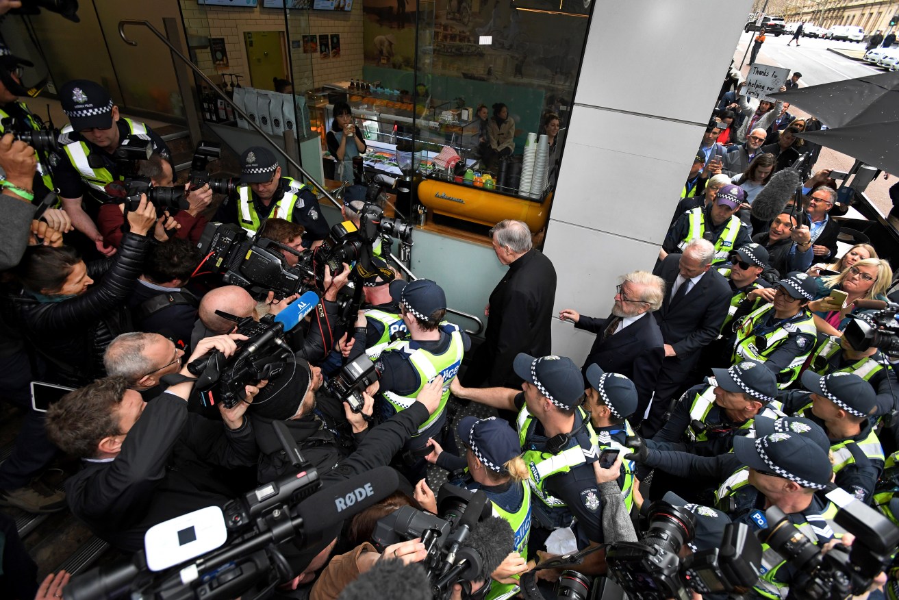 Cardinal George Pell surrounded by a huge media throng outside Melbourne Magistrates Court. Photo: AAP/Joe Castro