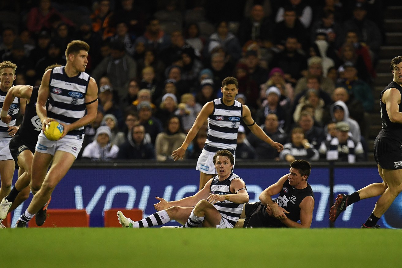 Patrick Dangerfield watches his teammates clear the ball after he brought Carlton ruckman Matthew Kreuzer to ground. Photo: Julian Smith / AAP