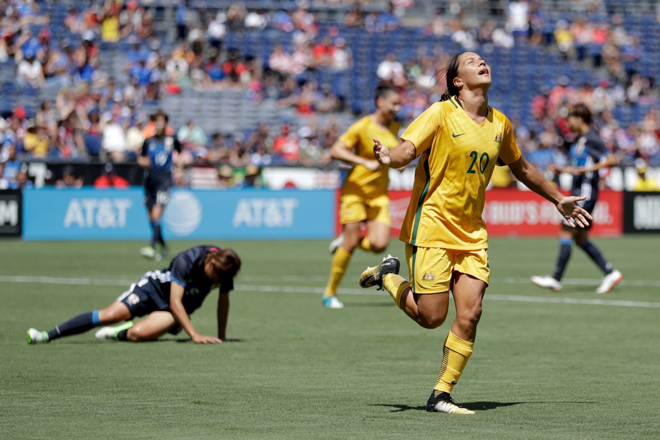 Australia forward Sam Kerr celebrates a goal as dejected Japan defender Rio Sakamoto looks on. Photo: Gregory Bull / AP