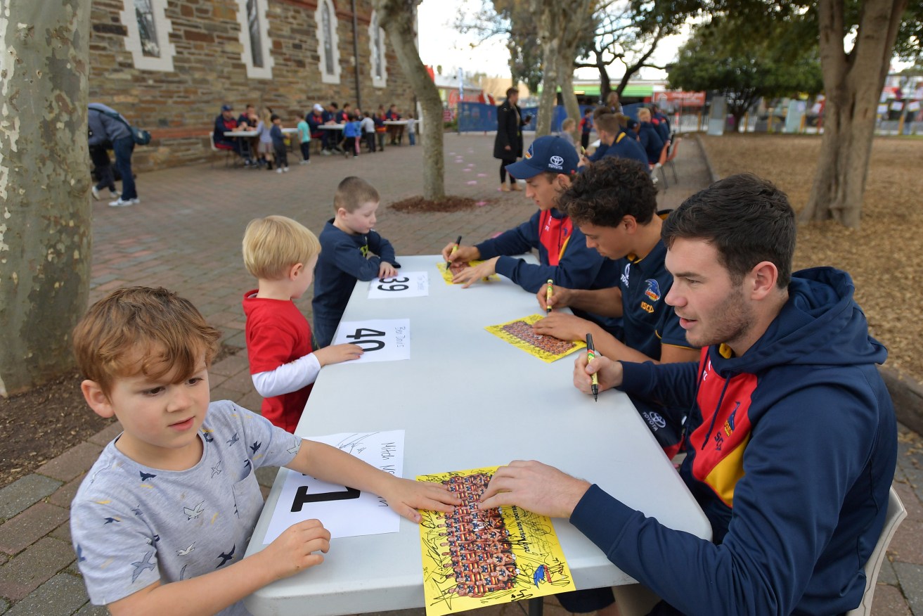 Mitch McGovern signs autographs at Goodwood Primary School this week. Photo: David Mariuz / AAP