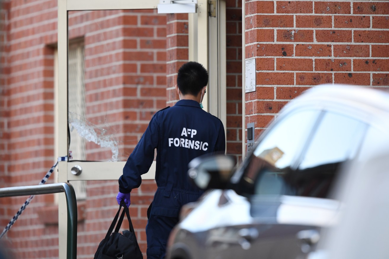 An Australian Federal Police forensic officer enters the main door of a building in Lakemba in Sydney this week.  Photo: AAP/David Moir