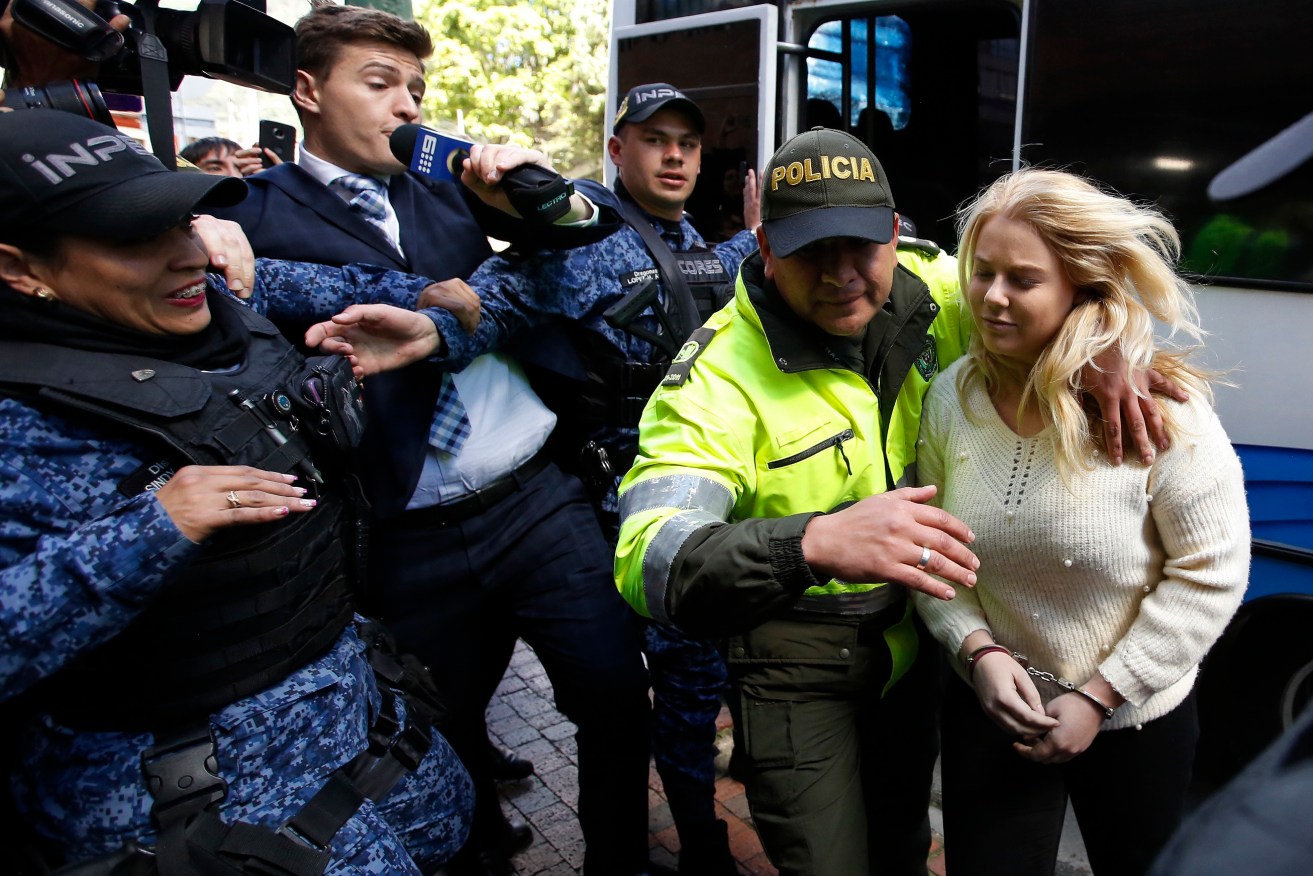 A police officer escorts Cassandra Sainsbury to her court hearing in Bogota, Colombia, today. Photo: AP/Fernando Vergara