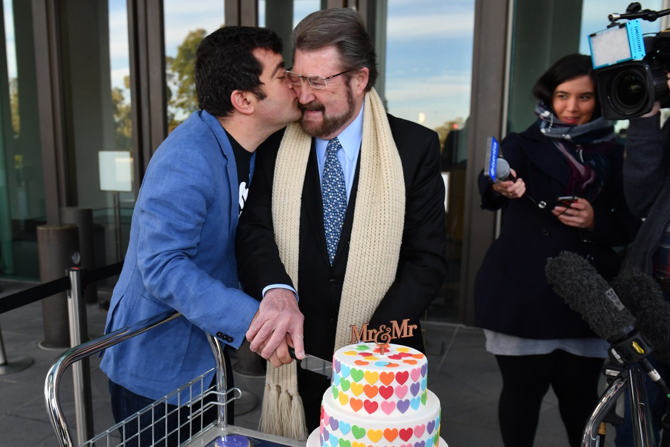 Labor Senator Sam Dastyari shares a cheeky kiss with Justice Party Senator Derryn Hinch after cutting a Marriage Equality Cake at the Senate doors this morning. Photo: Mick Tsikas / AAP
