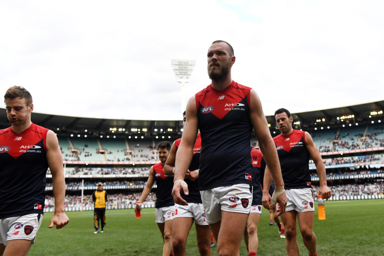 Demons players trudge off the MCG after their loss to Collingwood. Photo: Tracey Nearmy / AAP