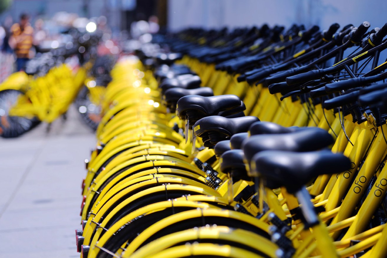 Bicycles from Chinese bike sharing service Ofo lined up on a Beijing footpath. Photo: AAP
