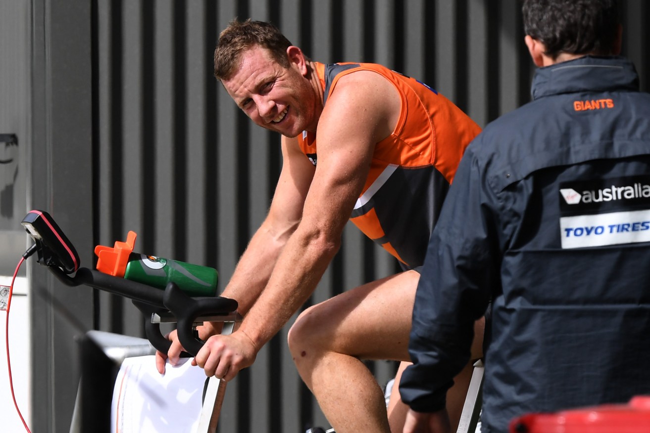Steve Johnson warms up on a bike during a team training session this week. Photo: David Moir / AAP