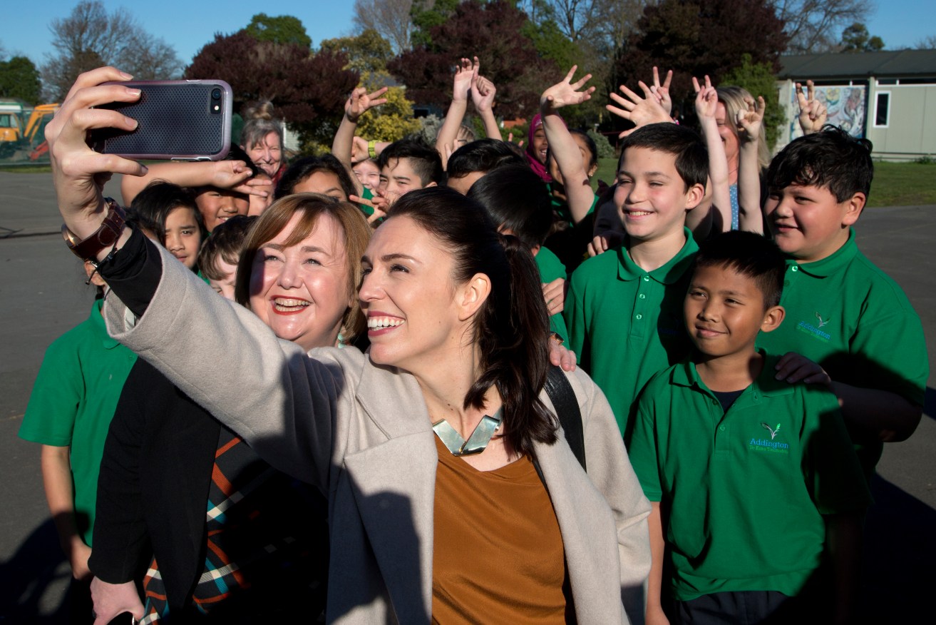 Labour Party leader Jacinda Ardern, front right, takes a selfie with school children during a visit to Addington School in Christchurch. Photo: AP/Mark Baker
