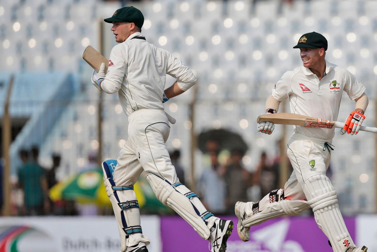 Peter Handscomb and David Warner run between the wickets in Chittagong. Photo: A.M. Ahad / AP