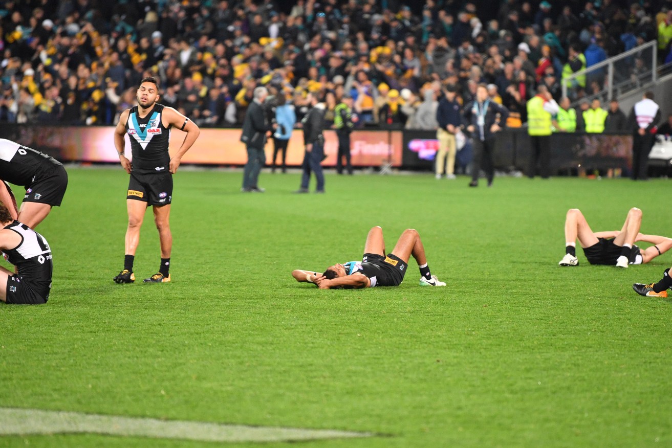 Dejected Port players - including Jared Polec (left), whose tackle on West Coast's Luke Shuey resulted in a free kick that determined the result - after Saturday night's game. Photo: David Mariuz / AAP
