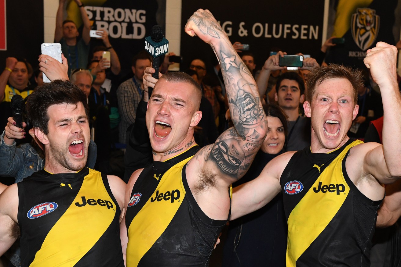 Dustin Martin celebrates Saturday's preliminary final win with Trent Cotchin and Jack Riewoldt. Photo: Julian Smith / AAP