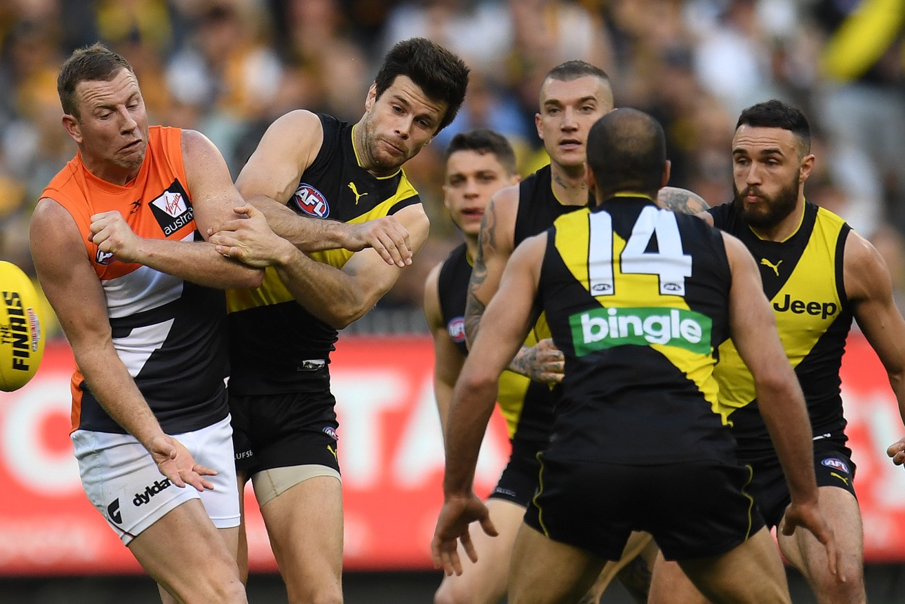 Trent Cotchin contests with retiring Giant veteran Steve Johnson during Saturday's final. Photo: Julian Smith / AAP