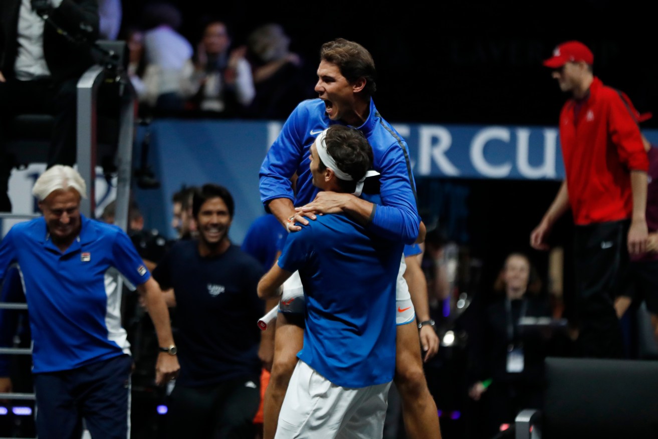 BROTHERS IN ARMS: Europe's Roger Federer celebrates with teammate Rafael Nadal after defeating World's Nick Kyrgios overnight. Photo: Petr David Josek / AP