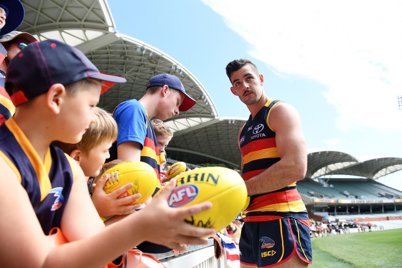 Crows captain Taylor Walker signs autographs following today's team training session at Adelaide Oval. Photo: Tracey Nearmy / AAP