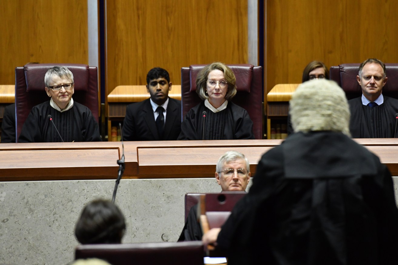 Attorney-General George Brandis speaks before the High Court, as Chief Justice Susan Kiefel (centre) looks on. Photo: AAP/Mick Tsikas