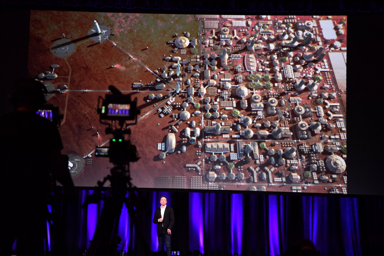 Elon Musk with a representation of a human colony on Mars, during his speech to the International Astronautical Congress in Adelaide on Friday. Photo: AAP/Morgan Sette