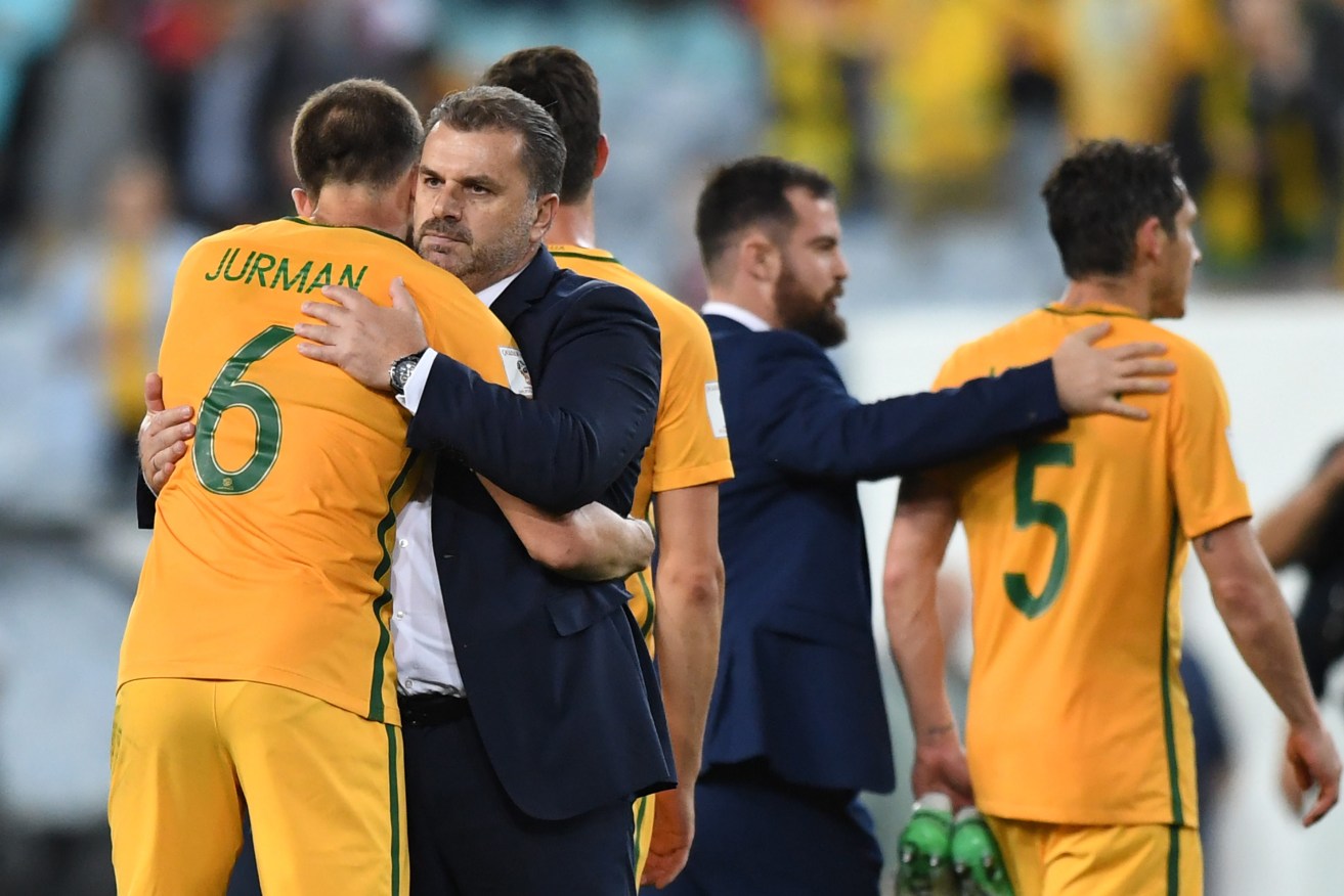 Australia head coach Ange Postecoglou celebrates with his players after last night's victory. Photo: AAP/David Moir